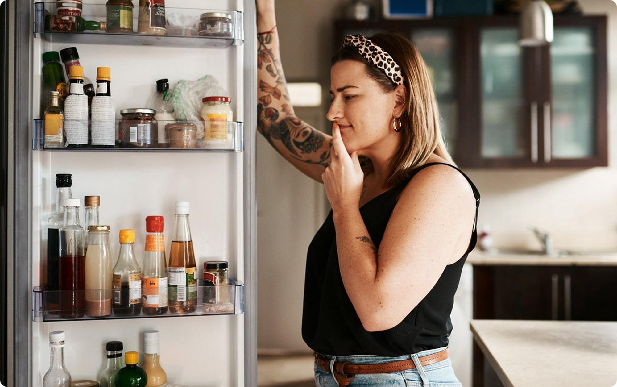 woman looking in refrigerator