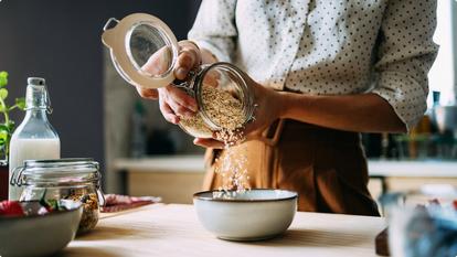 person pouring oatmeal into bowl