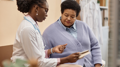 Doctor sitting with female patient looking at charts