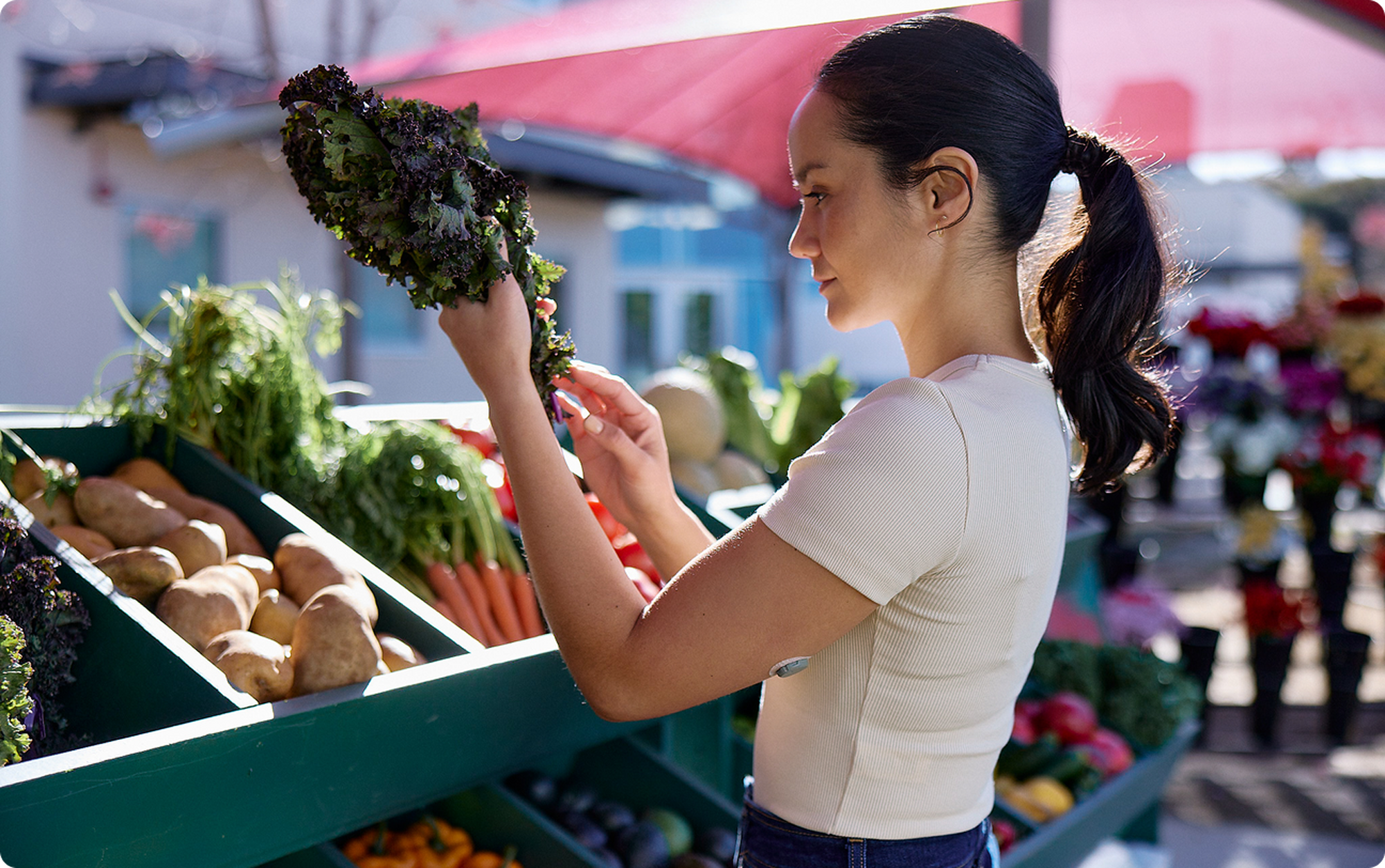 woman picking out kale at the market