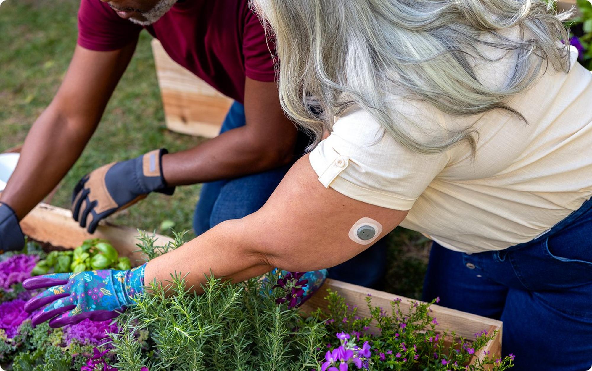 Woman wearing Stelo gardening with a friend 