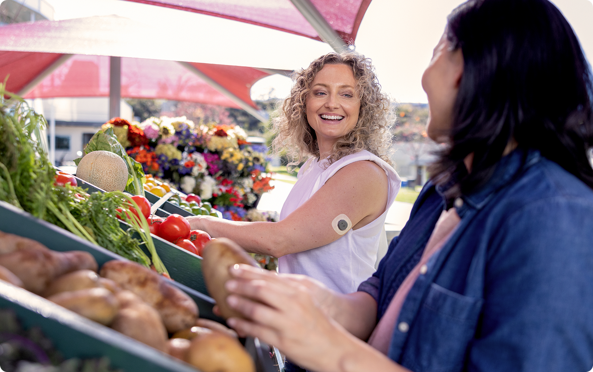 Two woman at the market, one wearing a stelo sensor