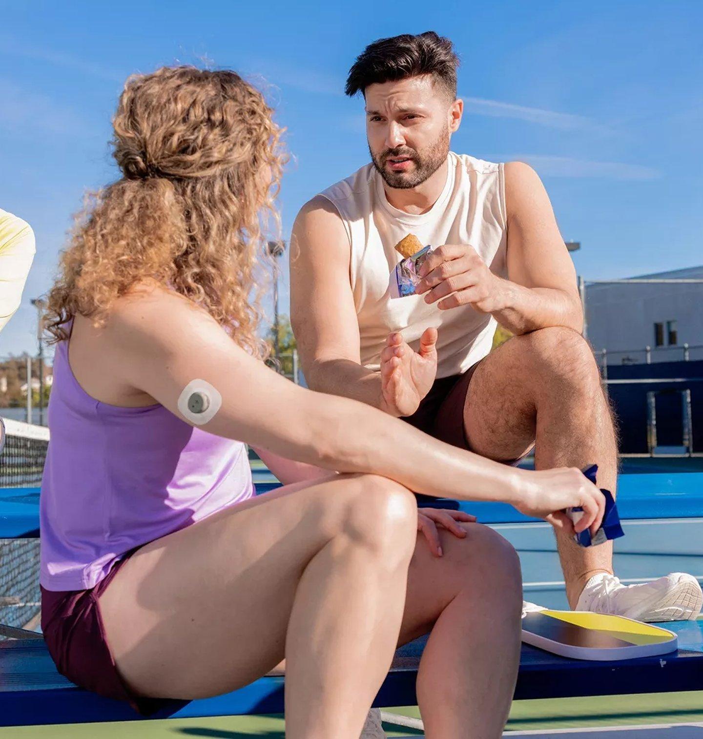 man and woman wearing stelo while taking a break from pickleball