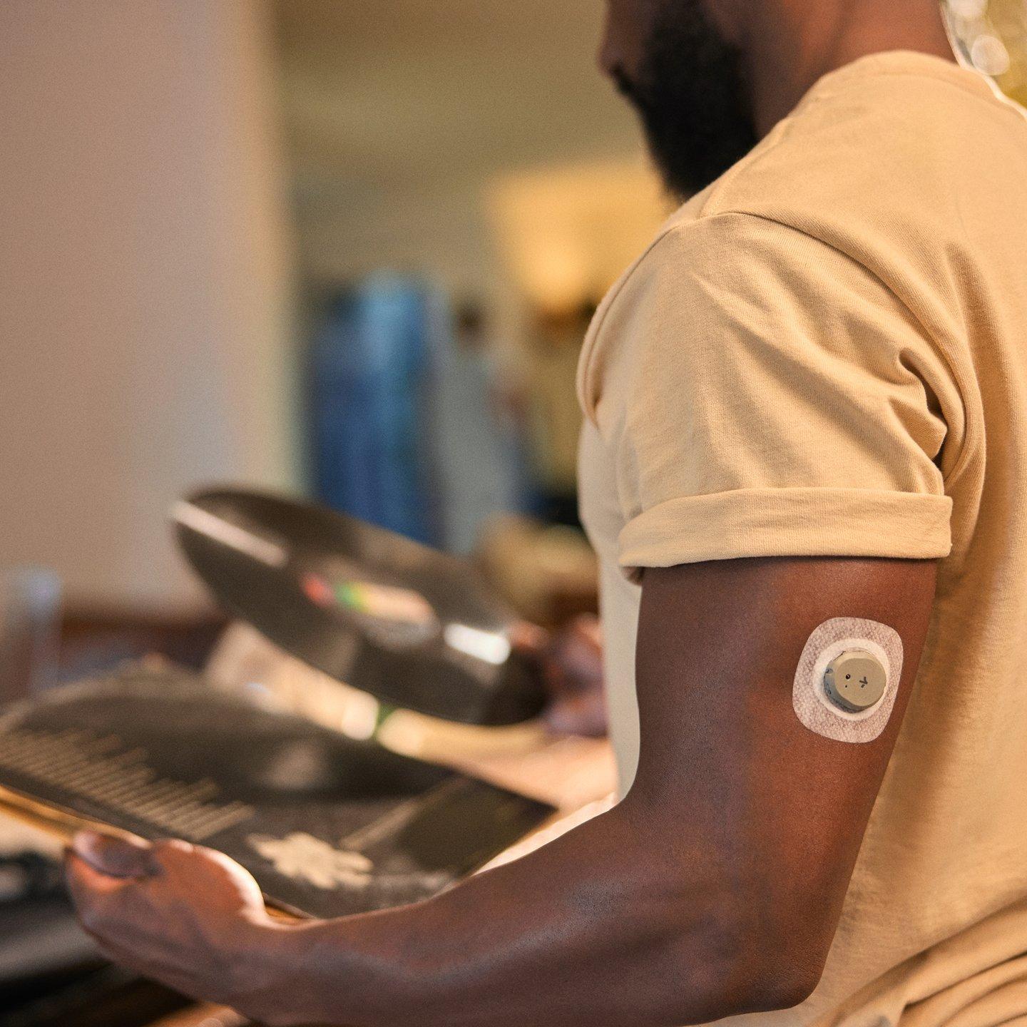 man wearing stelo looking at vinyl record