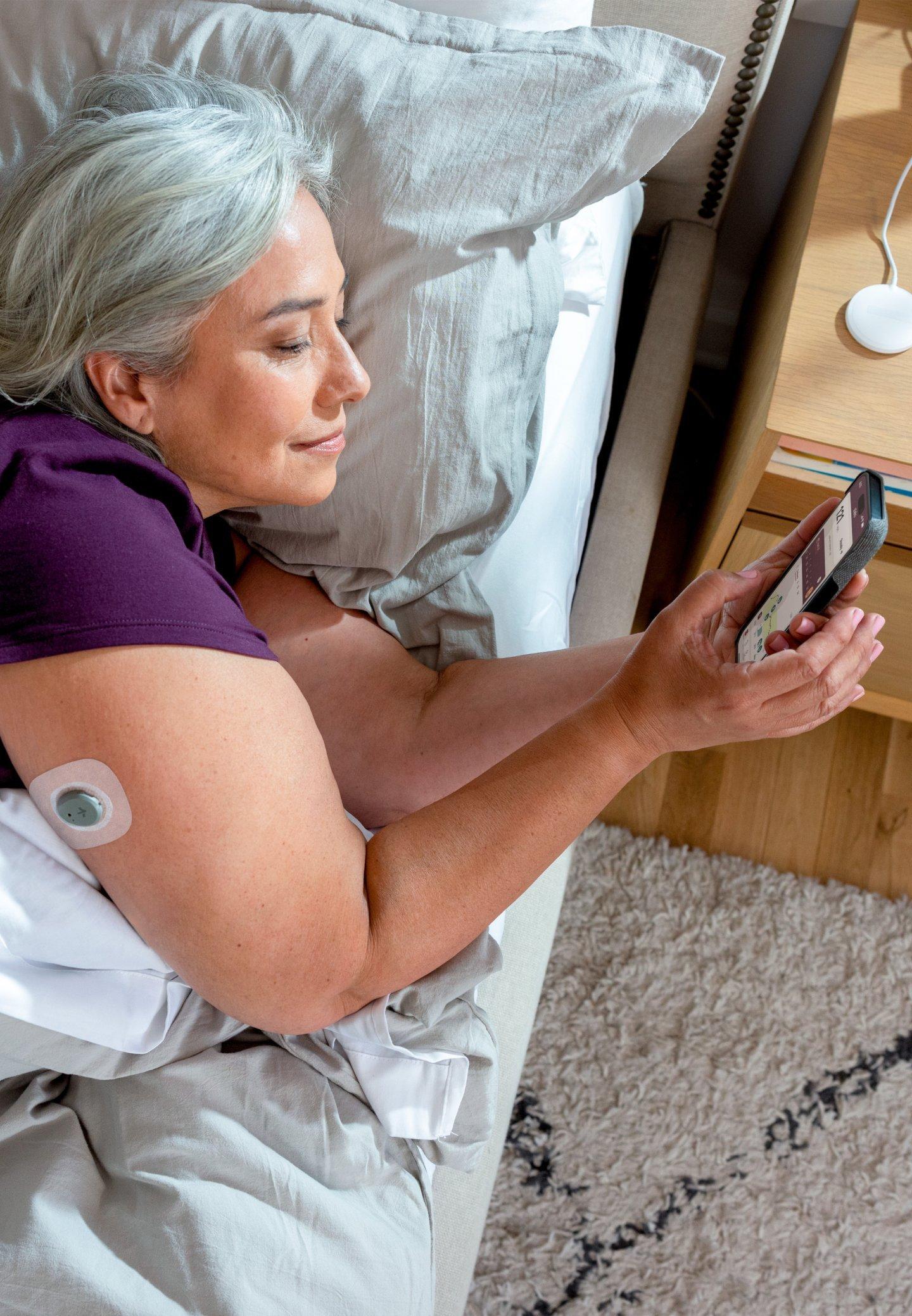 woman wearing stelo while laying in bed