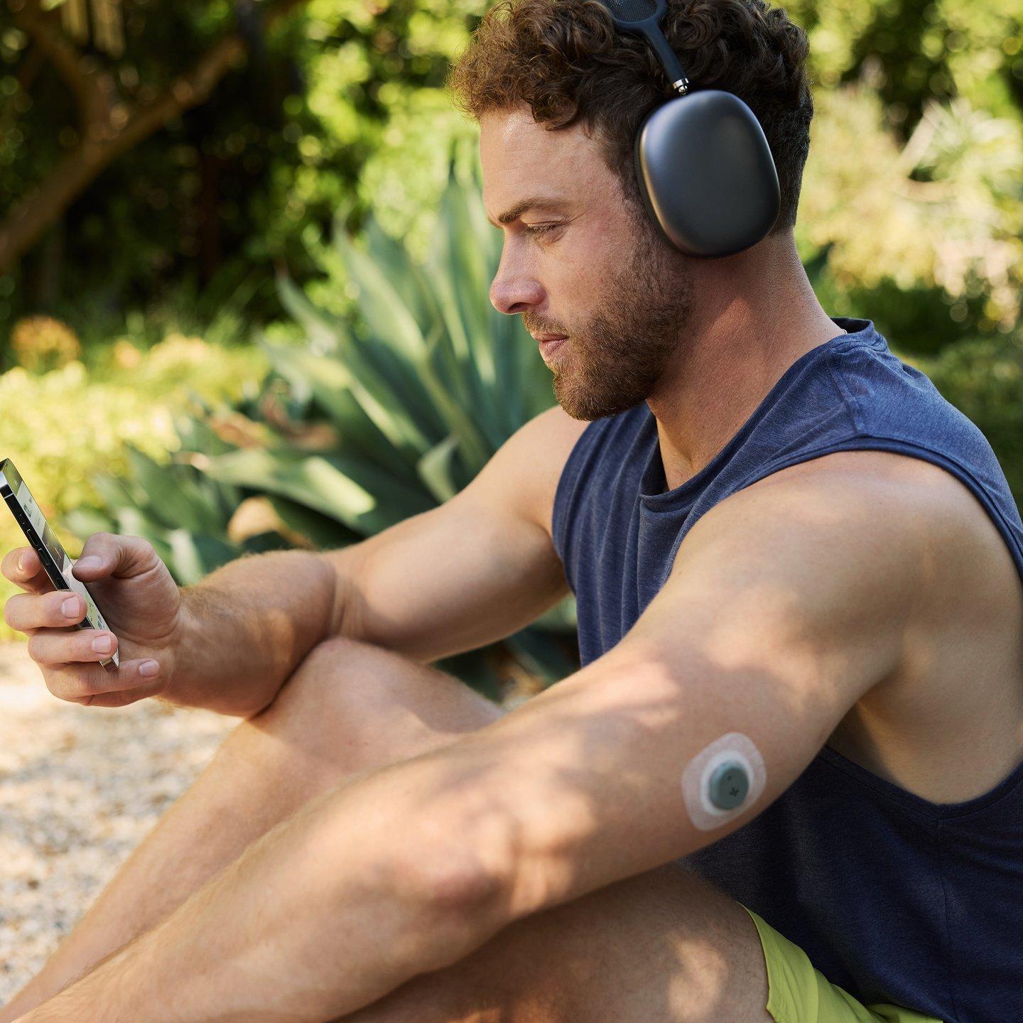 man wearing headphone and stelo biosensor