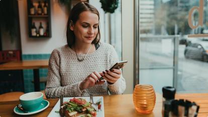 stelo woman eating at a restaurant on phone