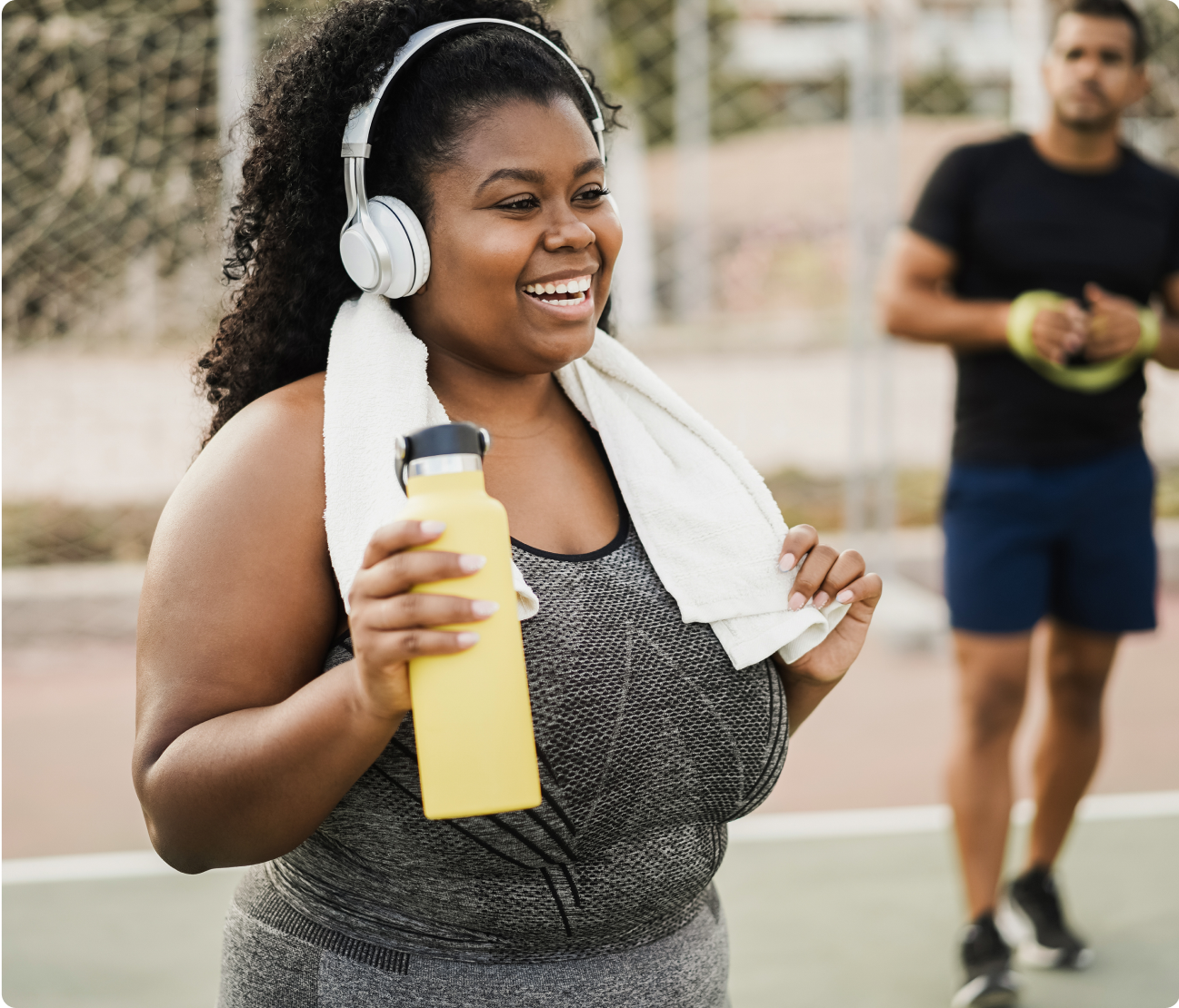 woman athlete laughing and holding drink and towel