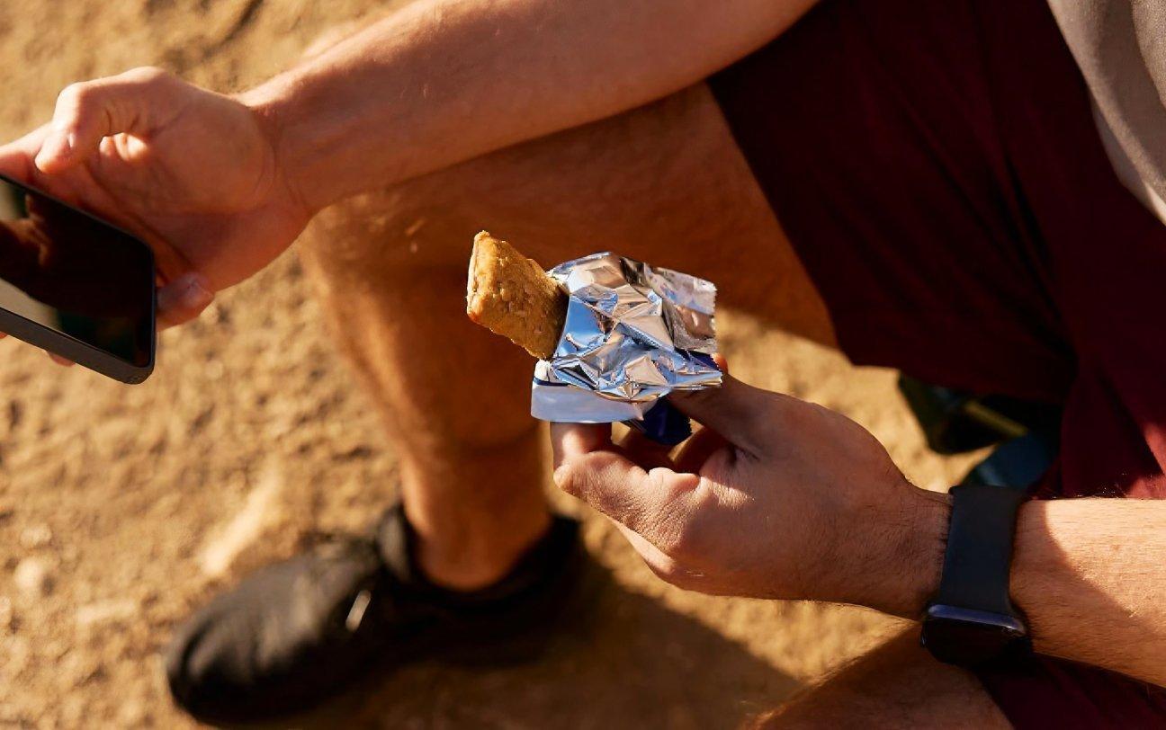 Man eating holding phone