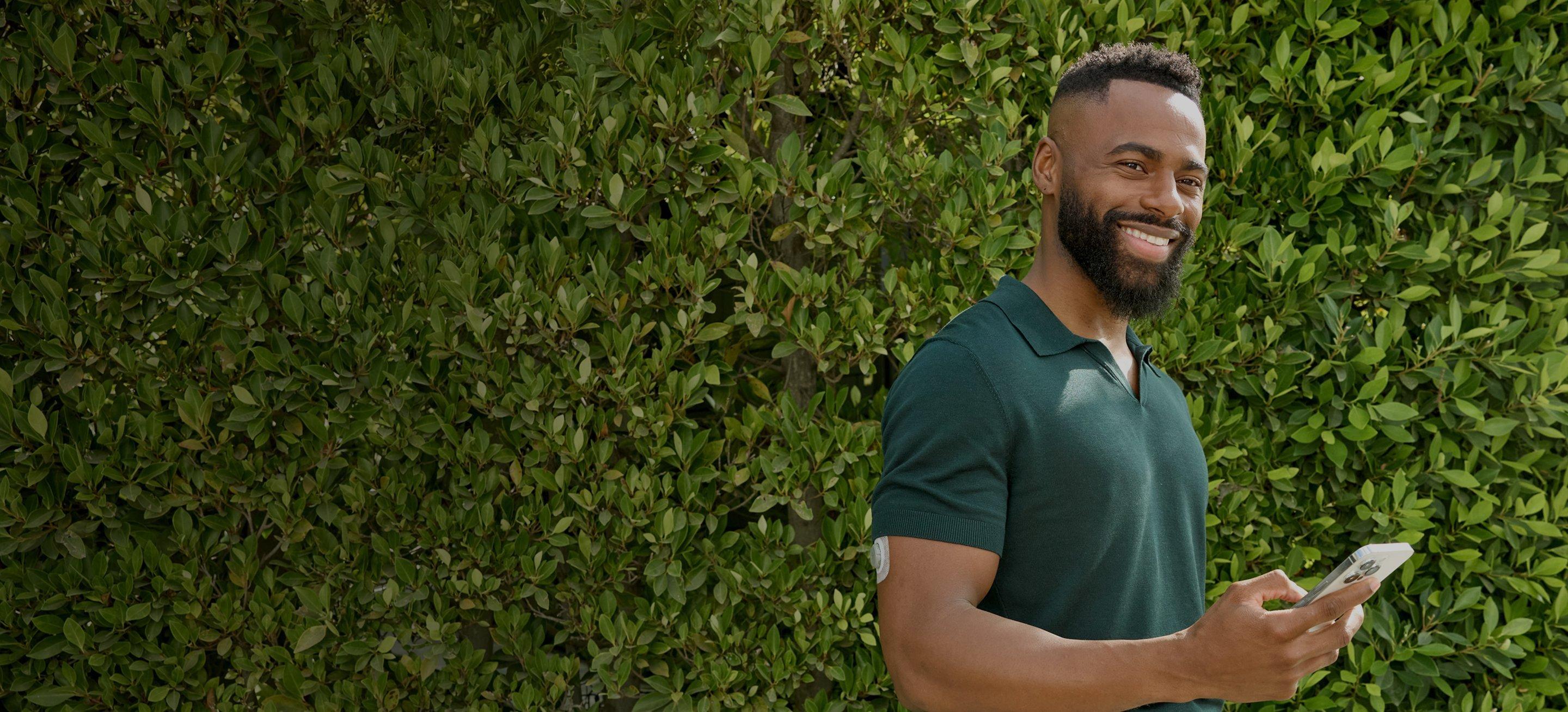 Man looking at Stelo app on smart phone wearing Stelo glucose biosensor