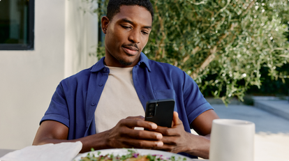 man checking phone during meal