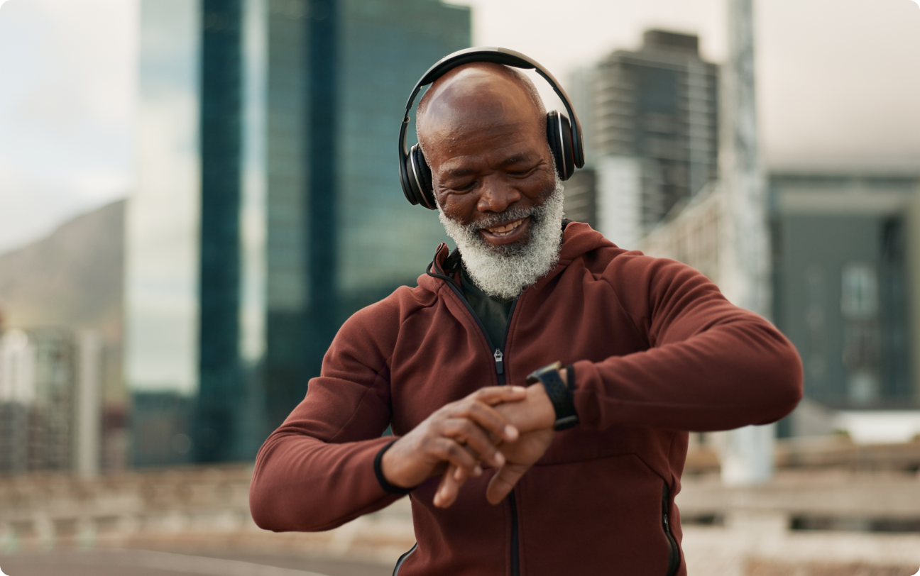 Man wearing headphones looking at smartwatch