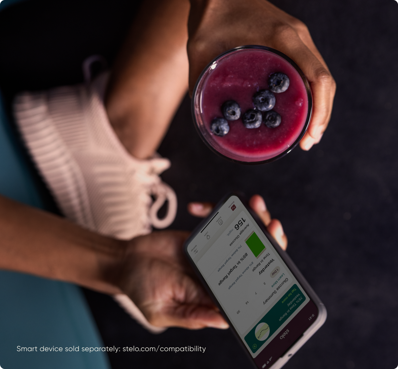 hands holding a smoothie and phone showing stelo app - smart device sold separately: stelo.com/compatibility