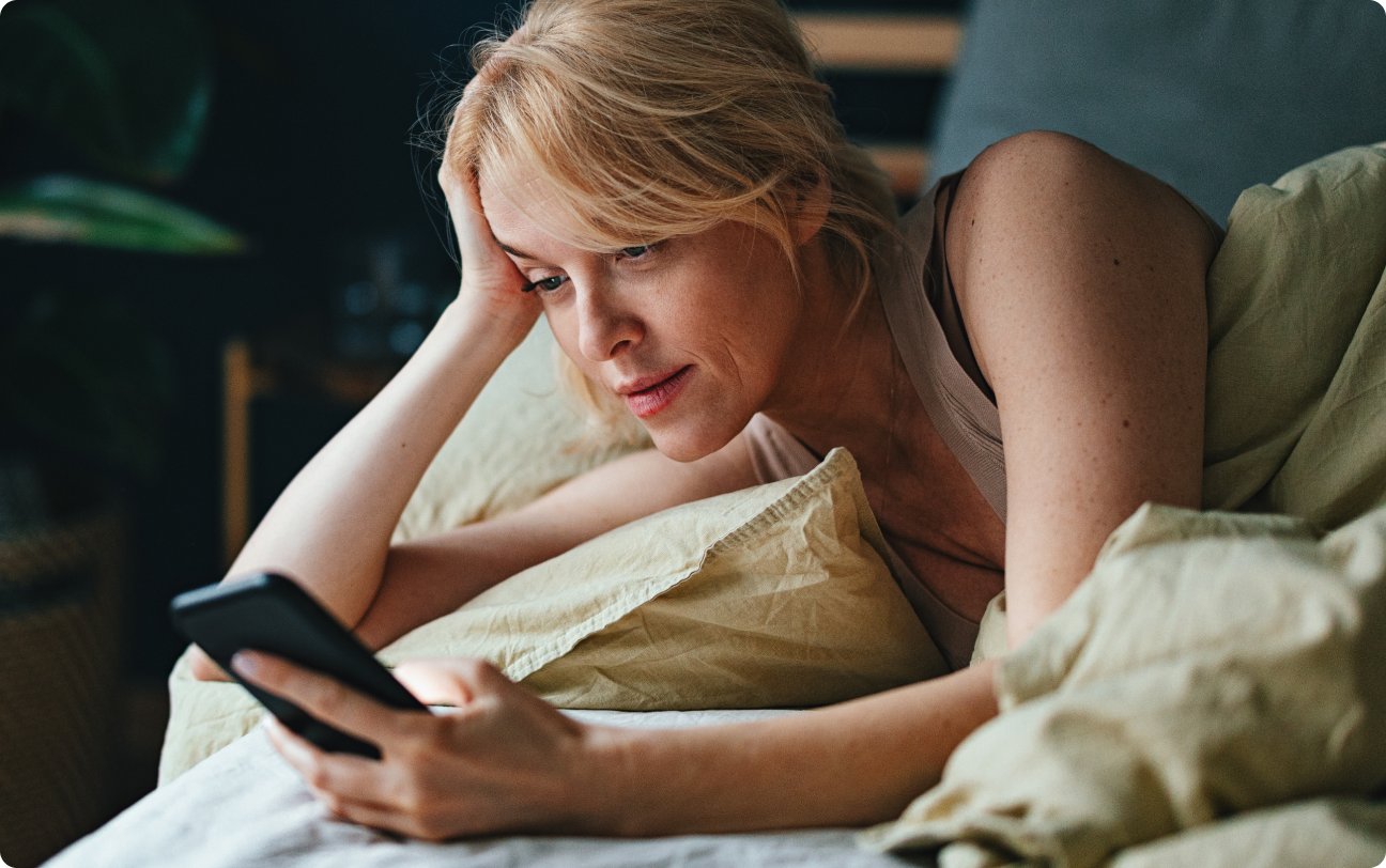 woman reading phone in bed