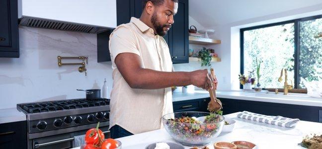 Man Tossing and eating a salad