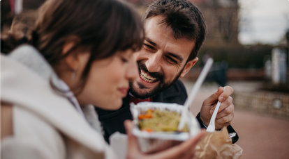 Woman and man eating together and laughing
