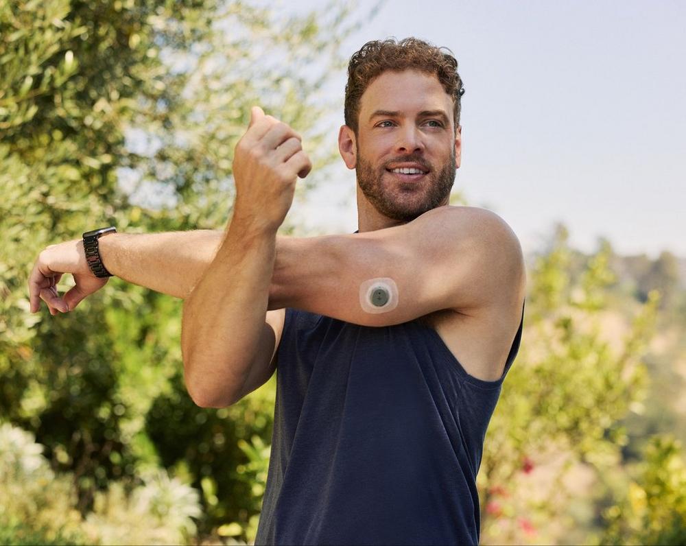 man stretching and wearing stelo glucose biosensor for health and wellness
