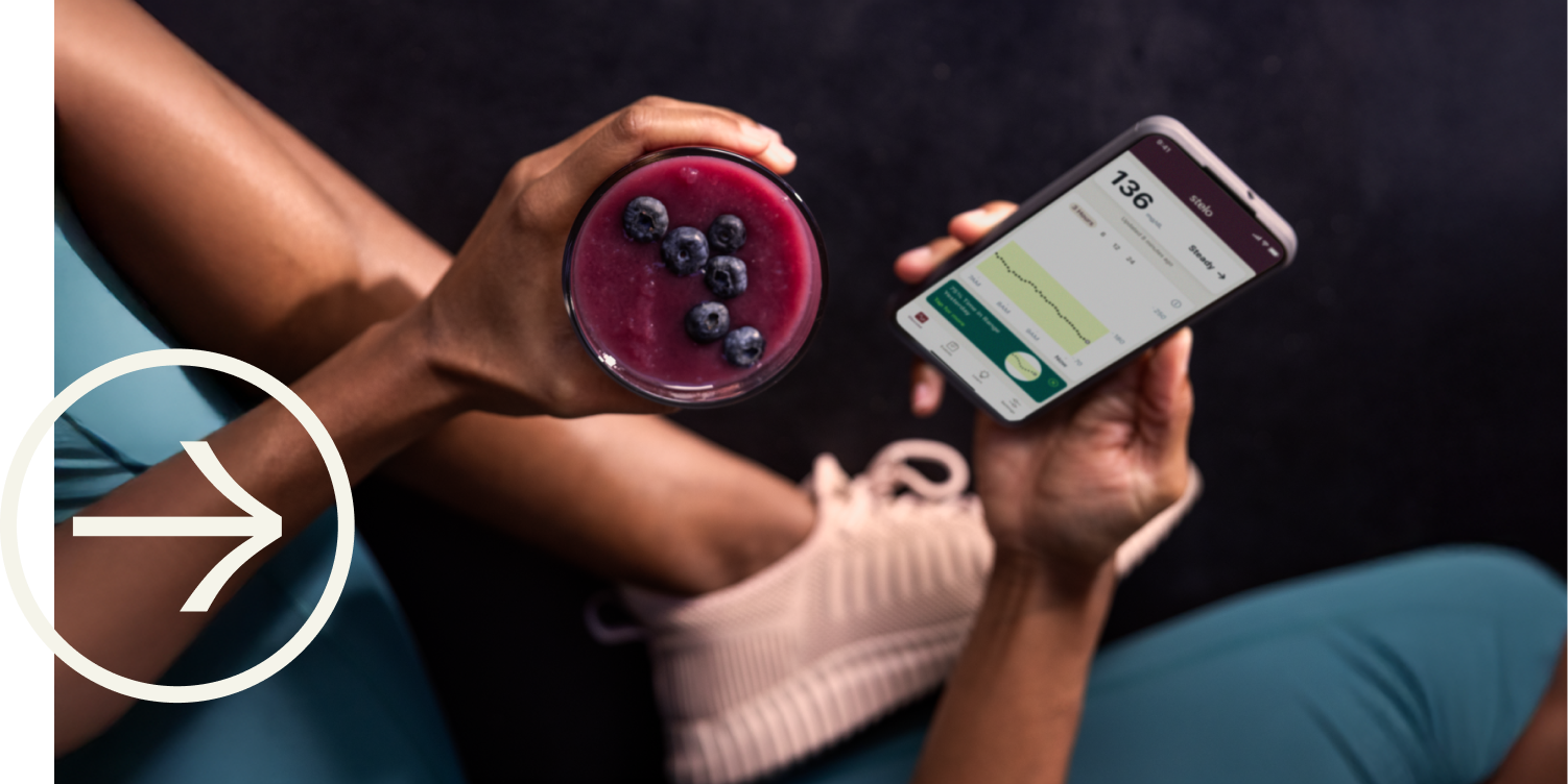 person holding healthy smoothie and smartphone with Stelo app
