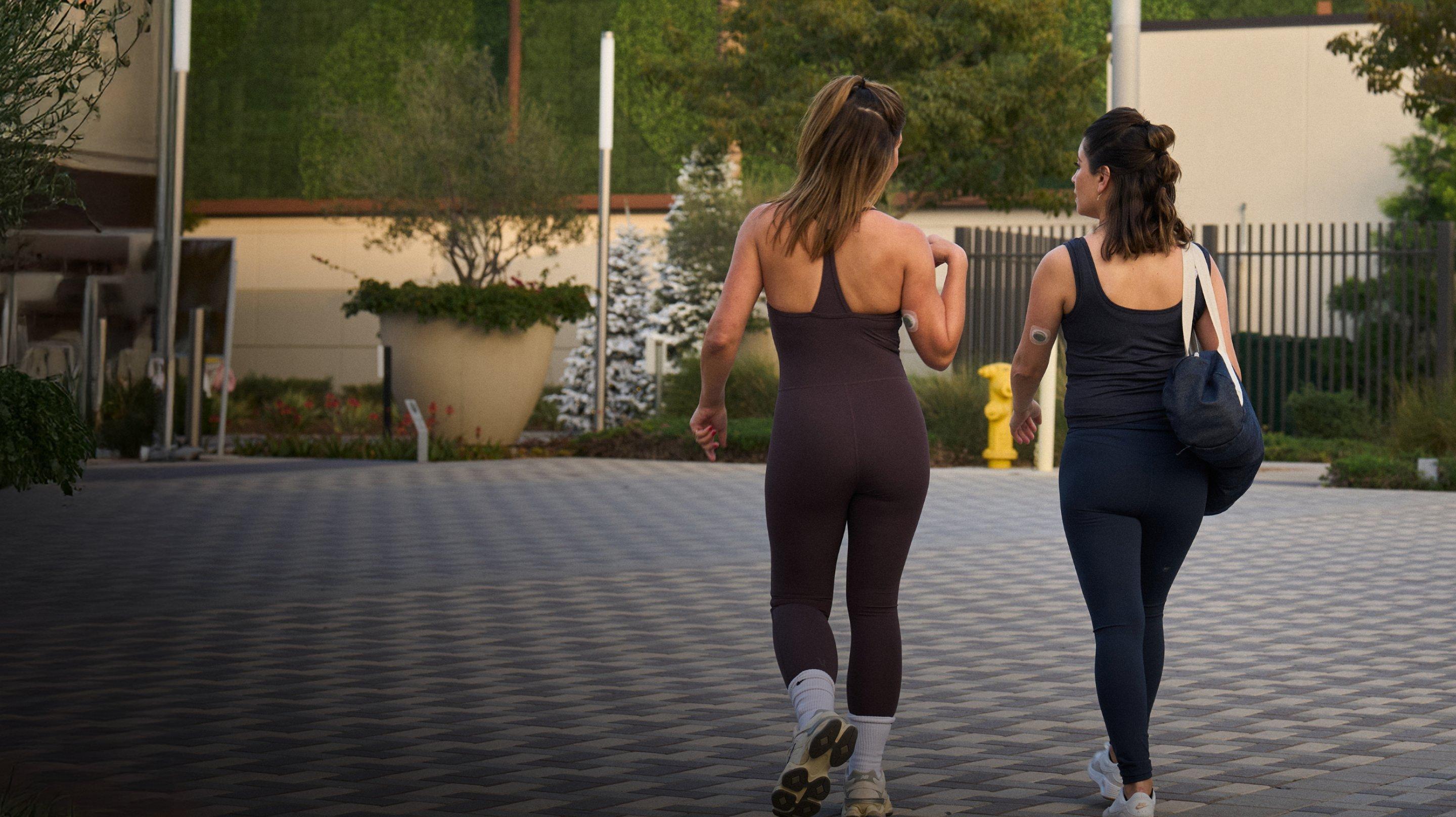 two women walking in workout outfits