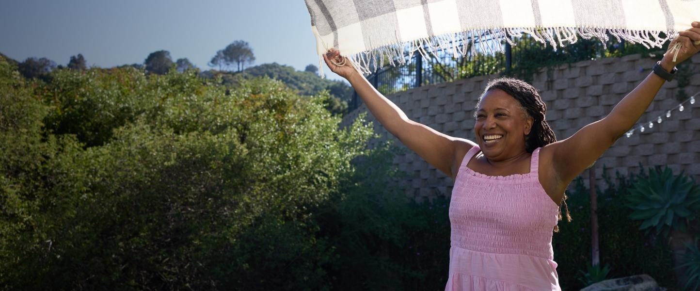 Woman outdoors throwing down a blanket