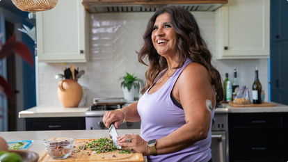 Woman chopping salad and wearing a stelo sensor