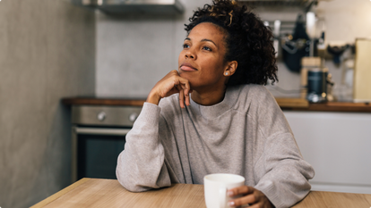 Woman drinking coffee in her kitchen