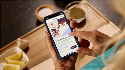 woman holding stelo app screen "what impacts my glucose"