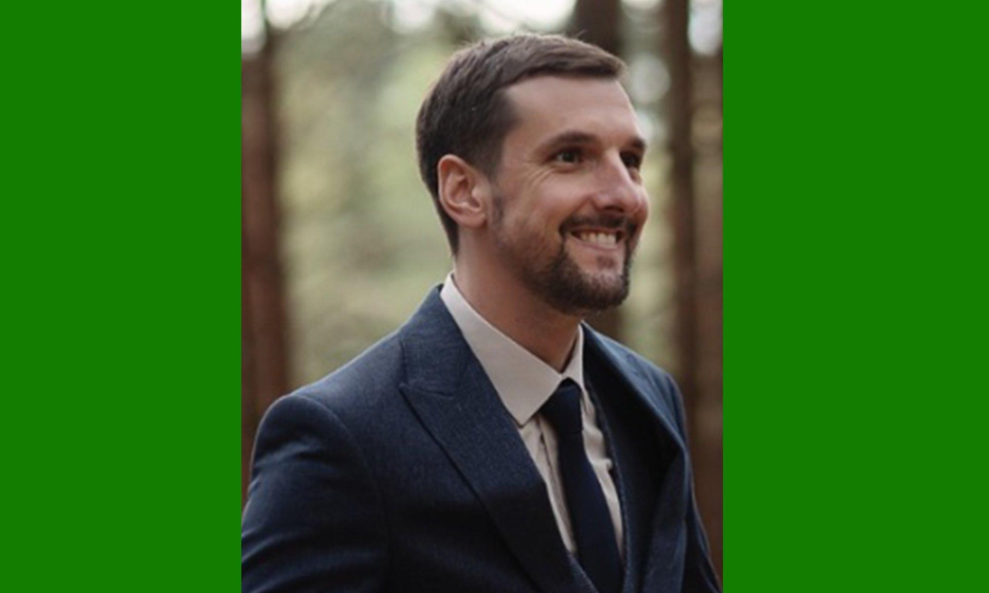 Young guy looking to the right side smiling with a blurry background