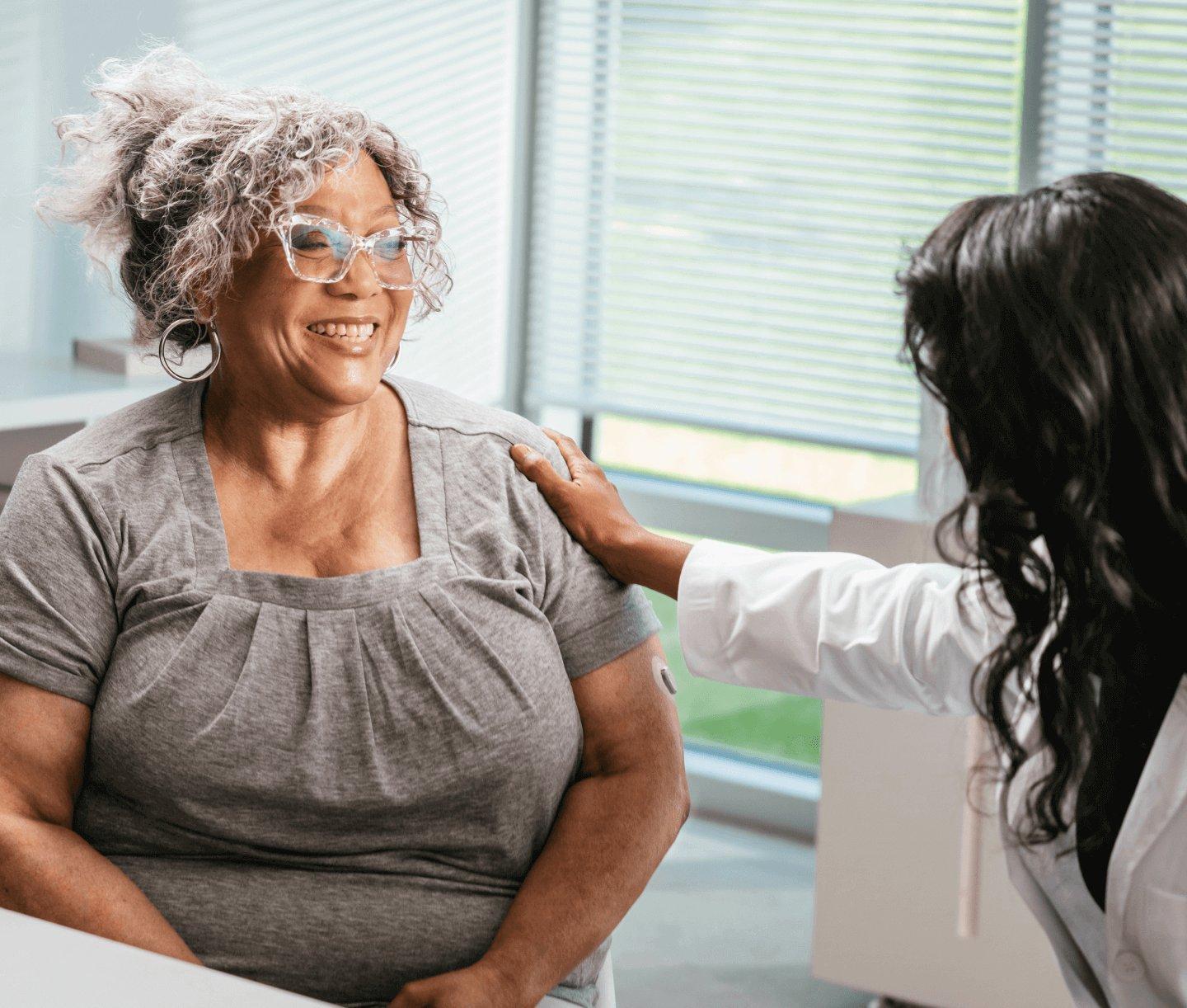 Woman wearing Dexcom G7 CGM talking to her doctor about Medicare options.