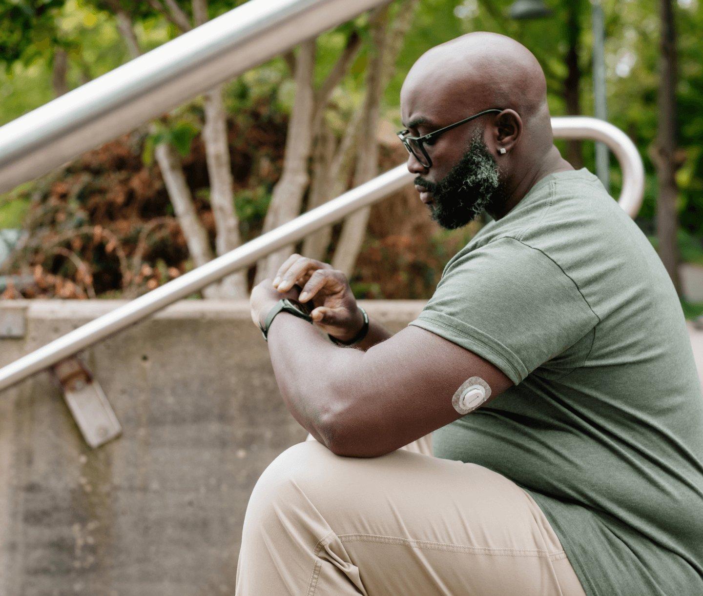 man checking his glucose reading on his smart watch with the Dexcom CGM