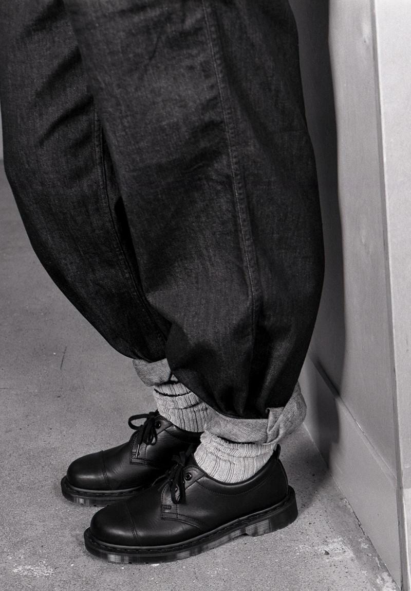 Black leather lace-up shoes with cuffed dark jeans and ribbed gray socks