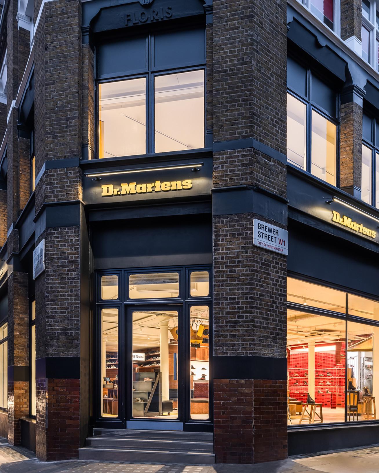Dr. Martens shopfront on a brick corner building, lit windows and Brewer Street W1 sign
