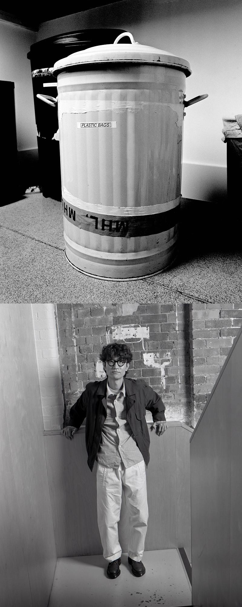 Black leather shoes on a person standing on a stair landing by a worn brick wall