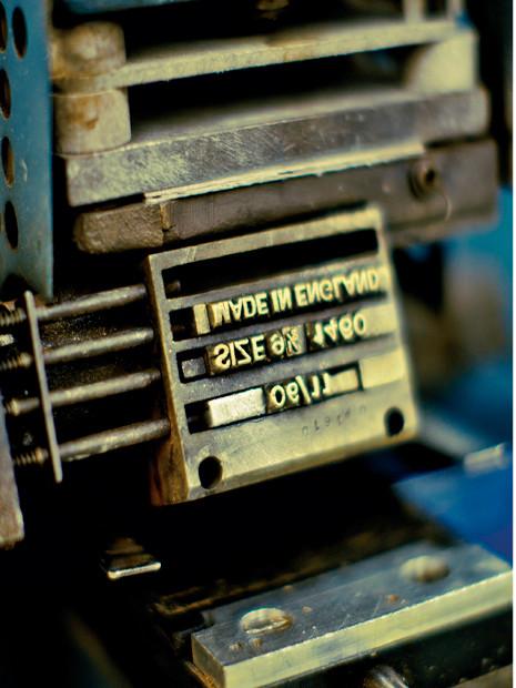 Close-up van versleten metalen letters op een drukpers, met inktvlekken