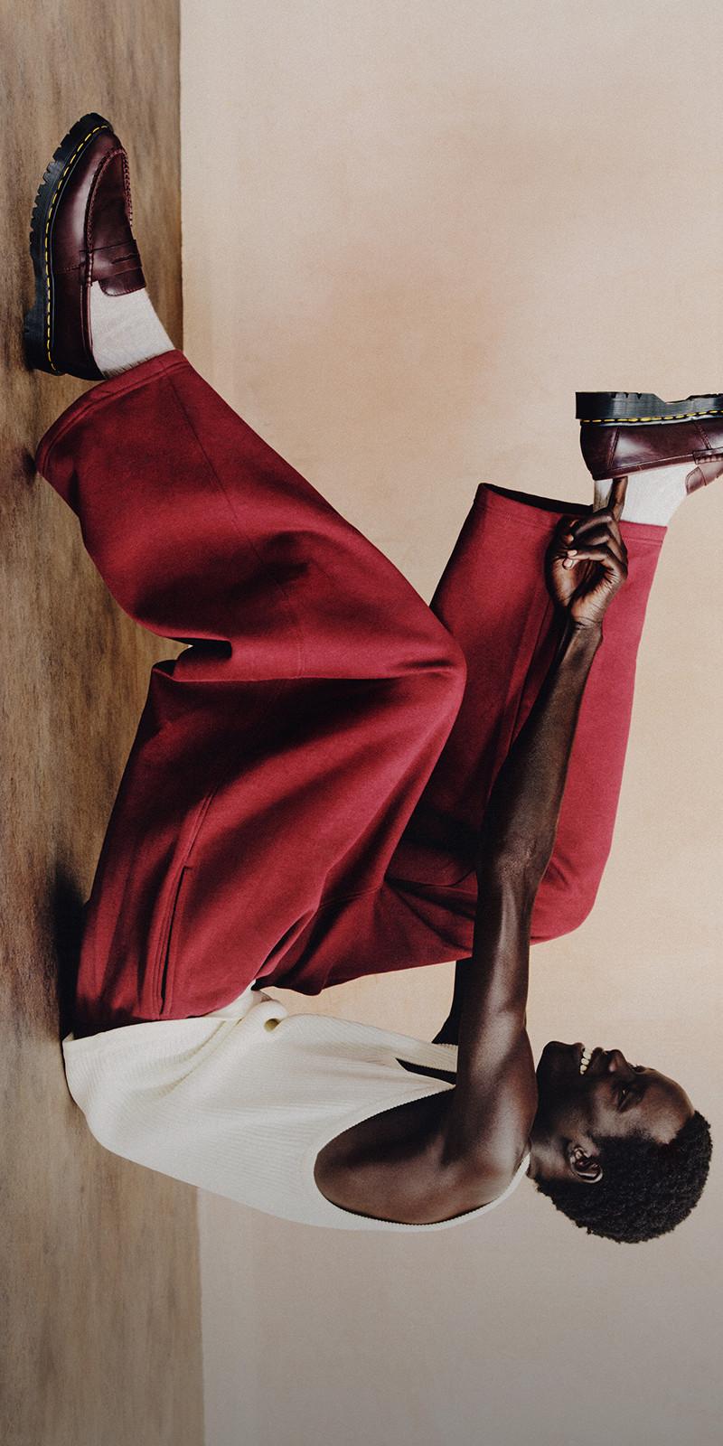 Burgundy leather loafers with yellow welt stitching, worn with white socks and red trousers