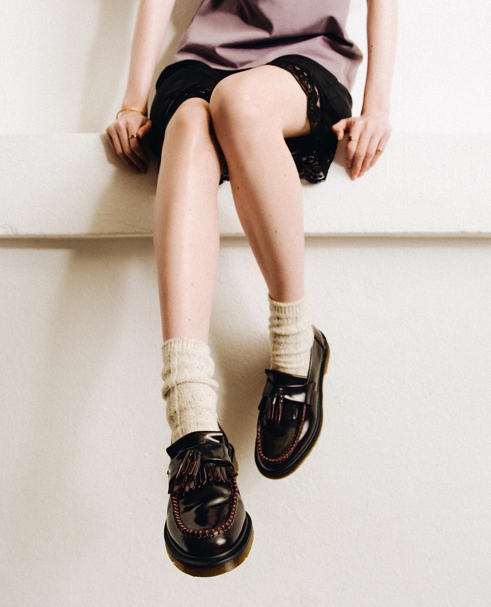 Burgundy leather tassel loafers with contrast stitching, worn with slouchy cream socks
