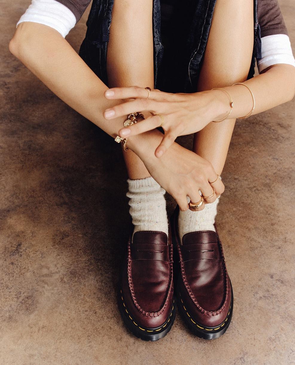Burgundy leather loafers with yellow welt stitching, worn with slouchy cream socks