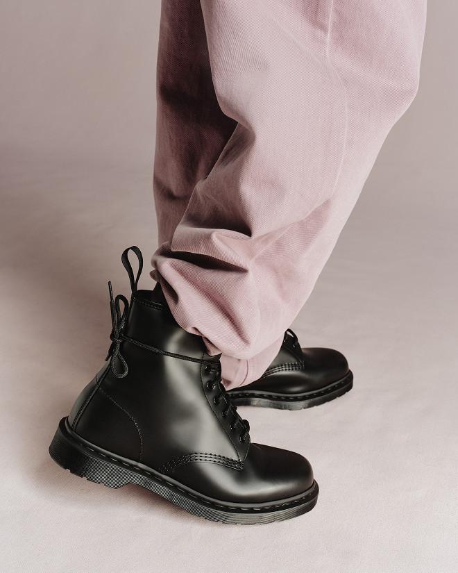 Black leather ankle boots with tonal laces, worn with pale pink trousers