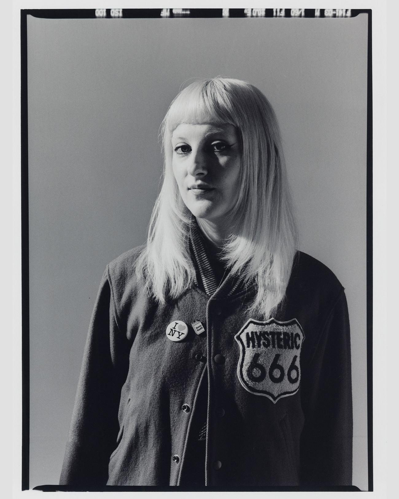 Black-and-white portrait of a person in a varsity jacket with ‘Hysteric 666’ patch