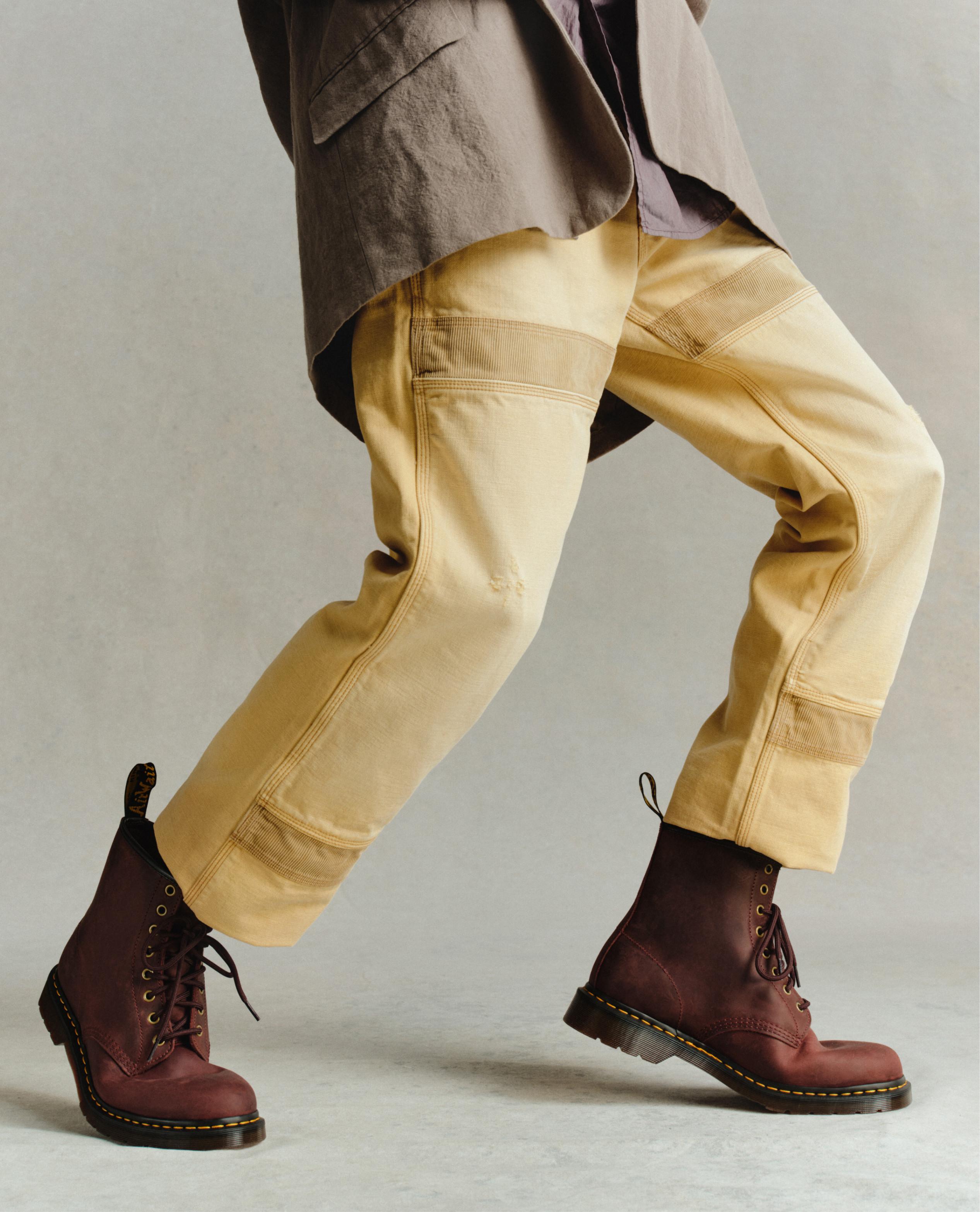 Botas de piel rojo cereza con cordones y pespunte amarillo, con pantalón arena