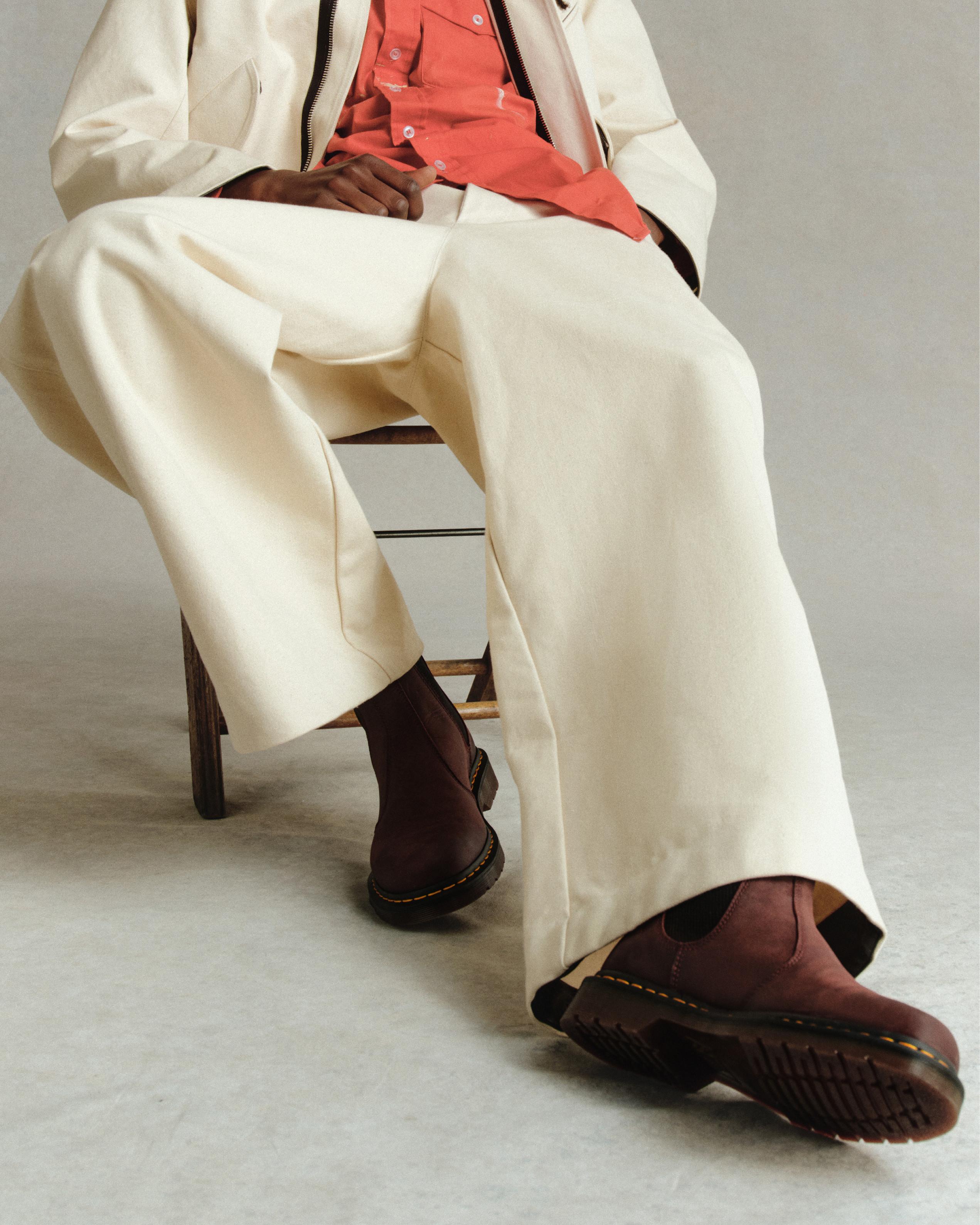 Botas Chelsea burdeos con costura amarilla, con pantalón crema de pernera ancha