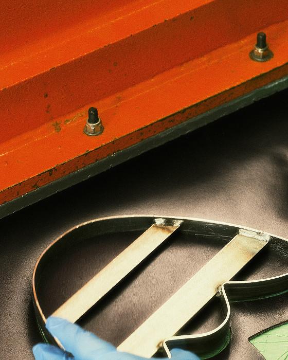 Schwarzer Lederriemen mit zwei hellen Holzeinsätzen auf dunkler Fläche