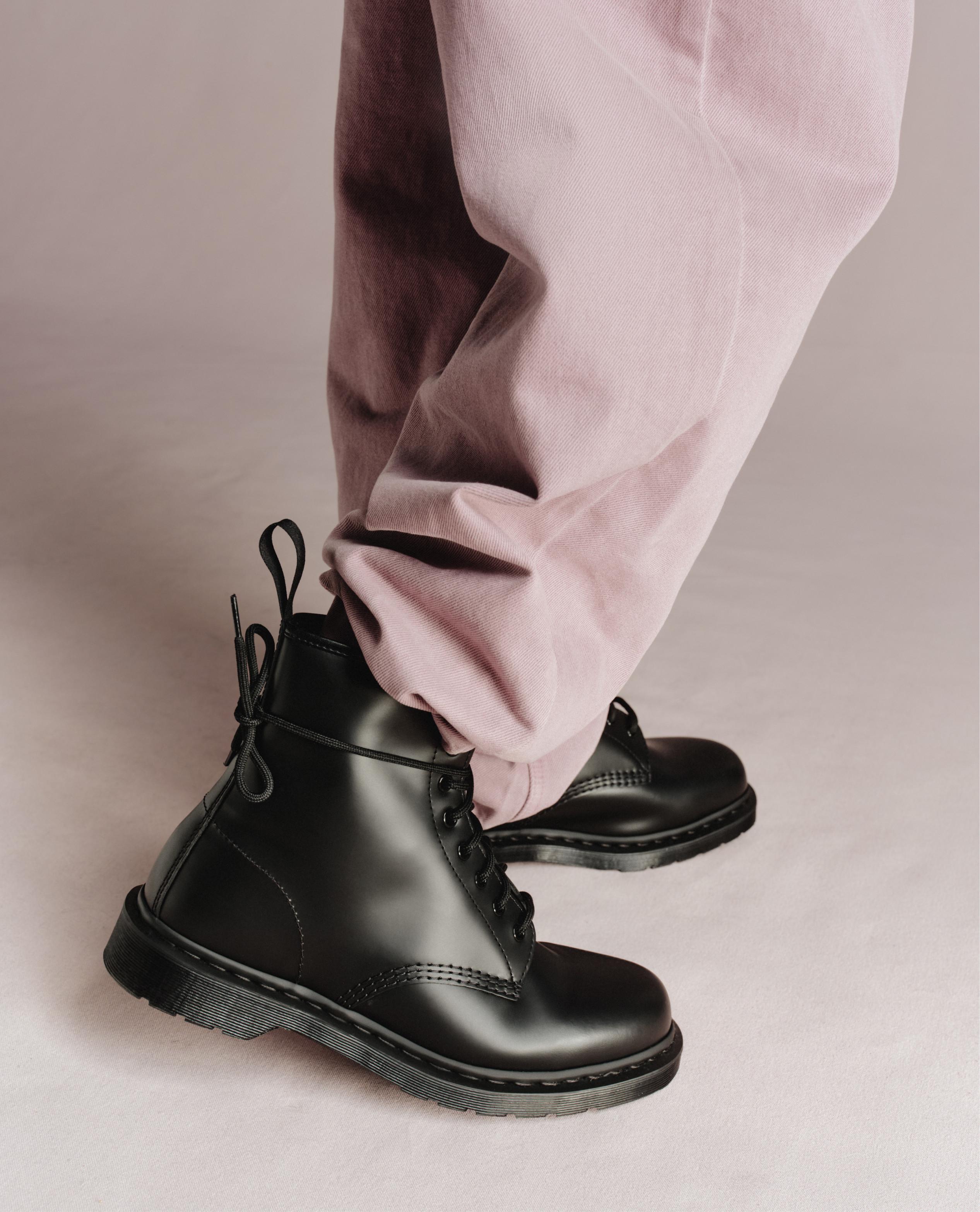 Black leather lace-up boots worn with pale pink trousers