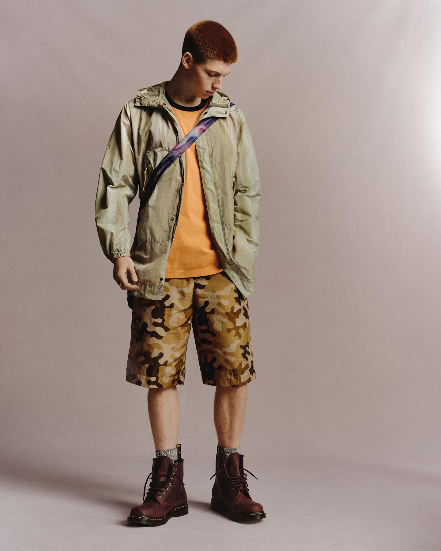 Burgundy leather lace-up boots worn with camo shorts and a khaki hooded jacket