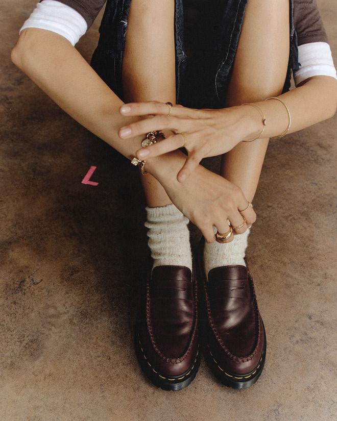 Burgundy leather loafers with yellow stitching, worn with slouchy white socks