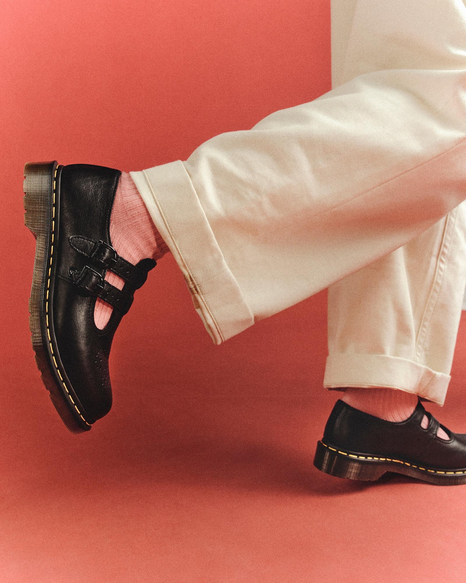 Black leather Mary Jane shoes with double buckles, worn with pink socks and cream trousers