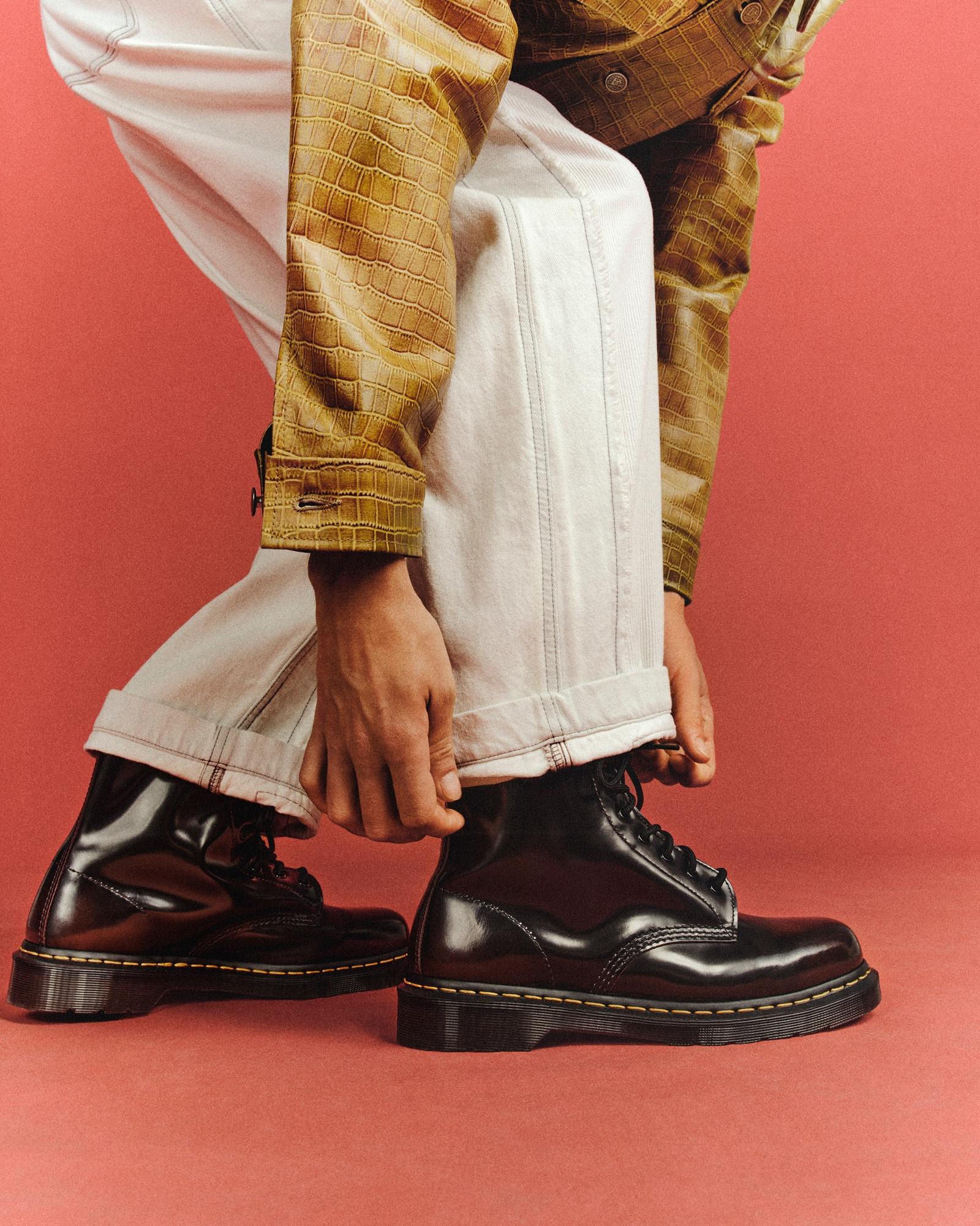 Black smooth leather 3-eye shoes with yellow welt stitching, worn with cuffed white jeans