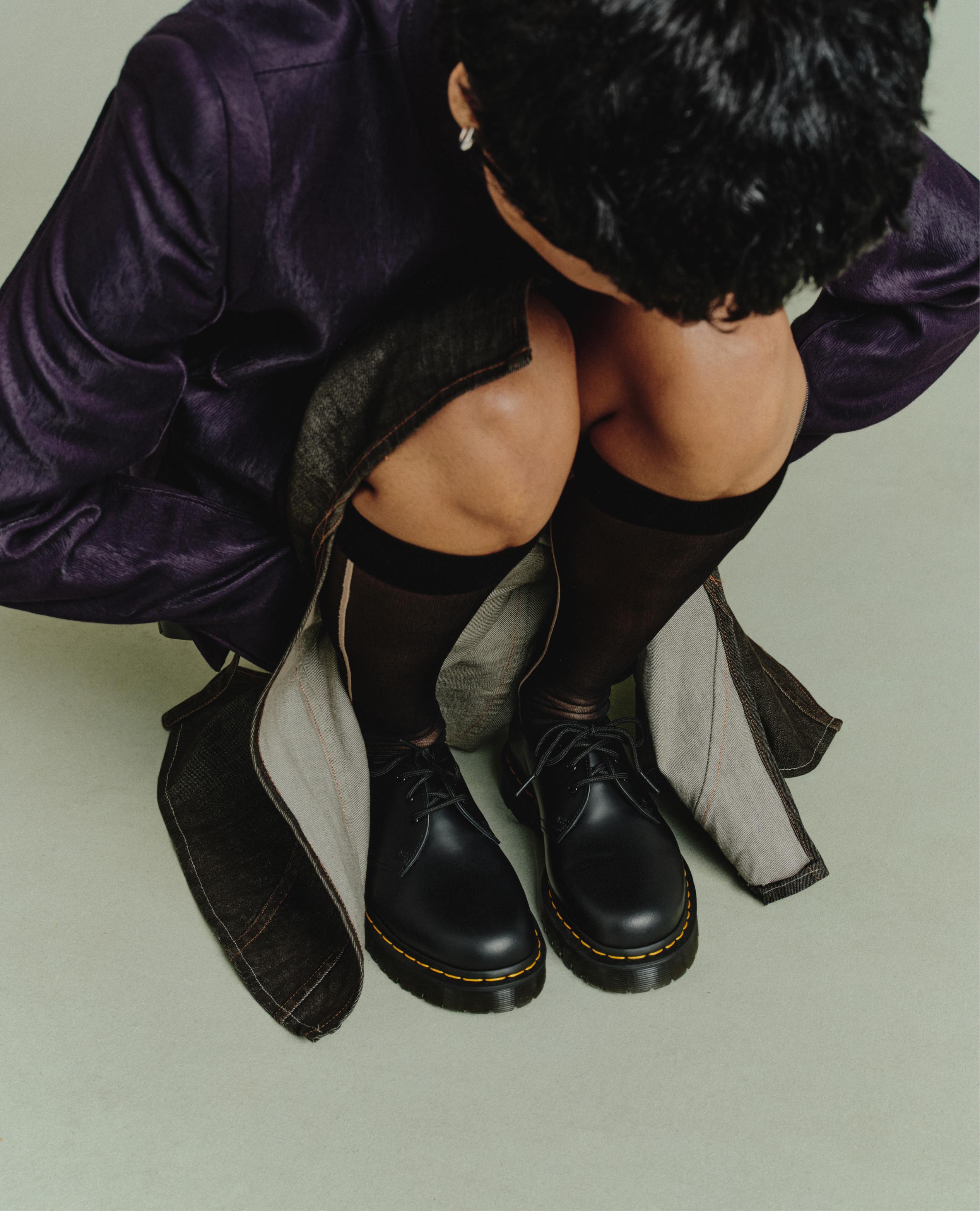 Zapatos negros de piel de 3 ojales con pespunte amarillo, con calcetas transparentes