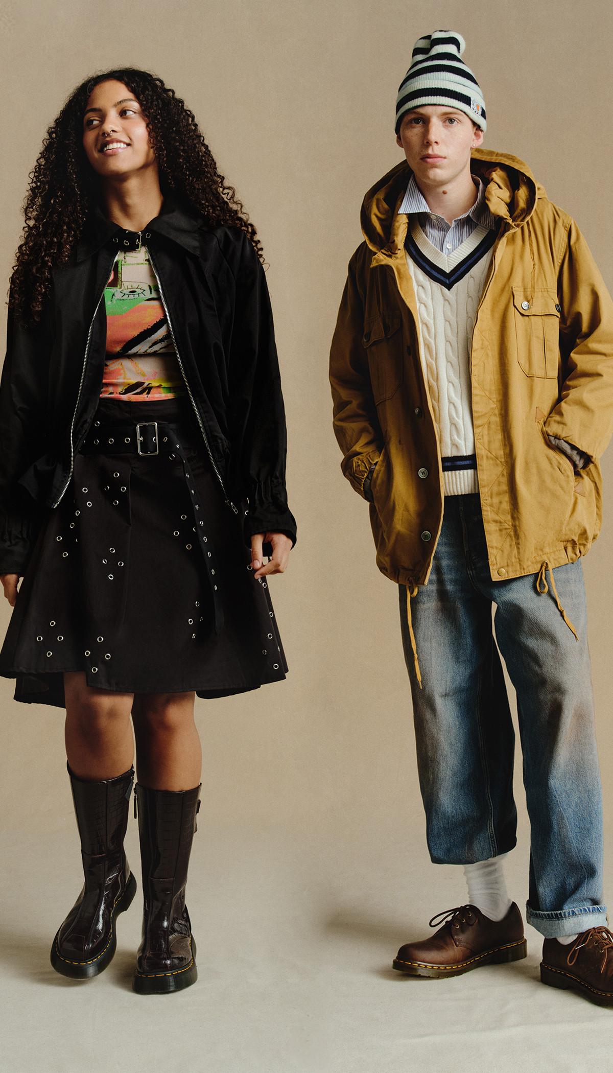 Dos modelos con botas y zapatos Dr. Martens, falda negra y chaqueta color camel