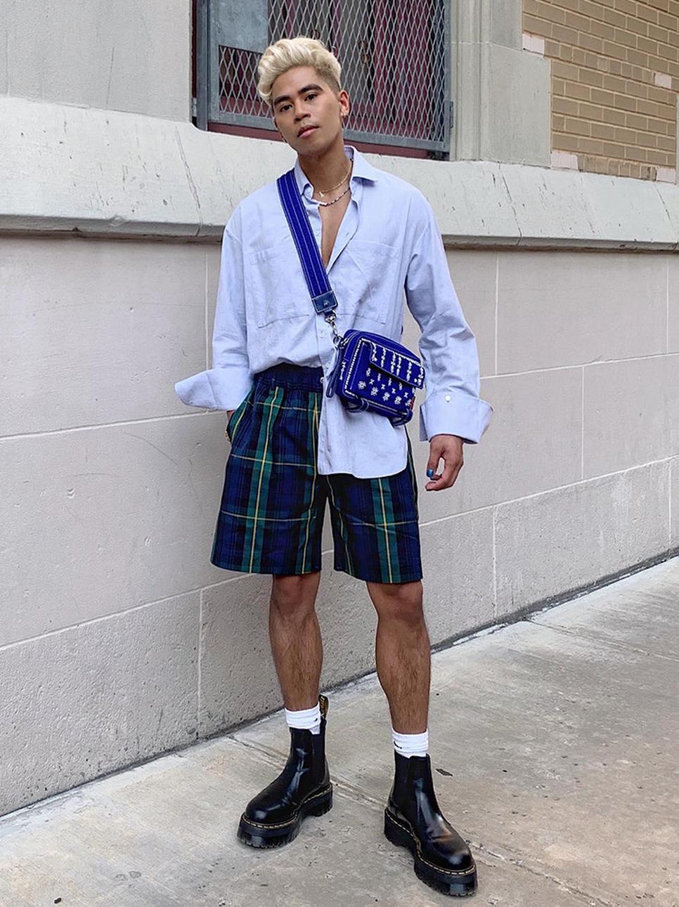 Person wearing a trendy outfit with a button down shirt and patterned shorts styled with platform chelsea boots